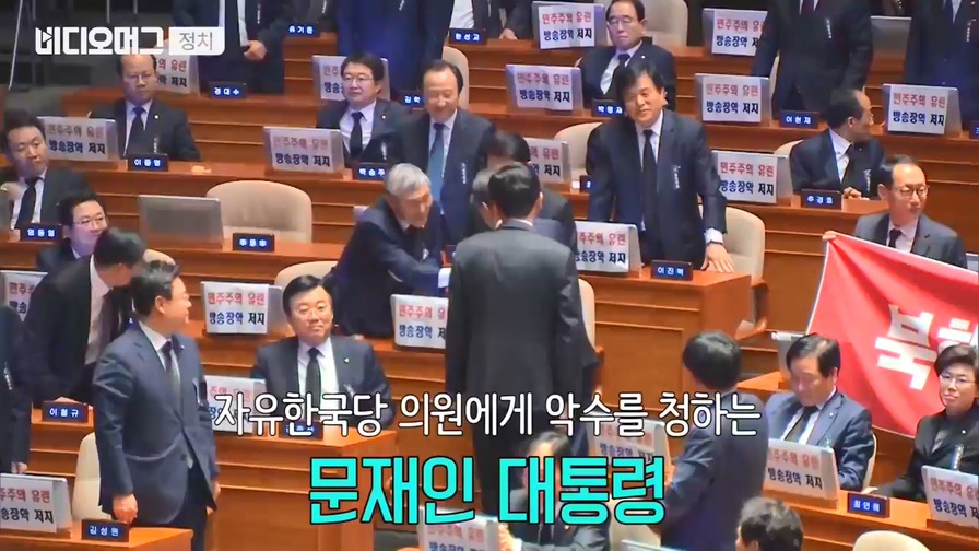 현수막 시위하는 자유한국당에 웃으며 악수하는 대통령.jpg | 인스티즈